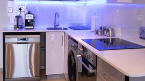 A modern kitchen with stainless steel appliances, a dishwasher, and a built-in oven.