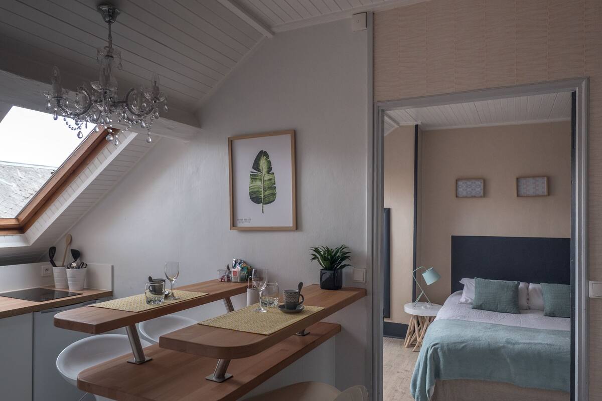 Una cocina moderna con encimera de madera, una lámpara colgante y un tragaluz.