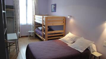 A room with a bunk bed, a desk, and a chair.
