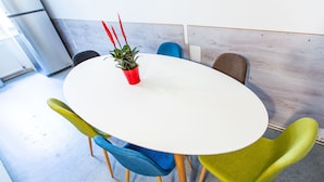 A round table with a potted plant, surrounded by colorful chairs. - Vienna Opera Appartment - free PARKING (Vienna)
