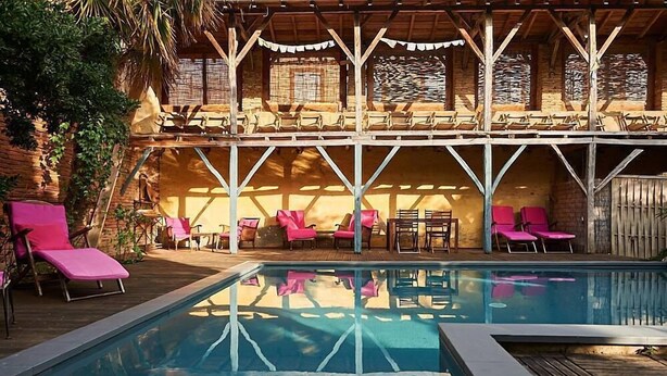 A pool area with lounge chairs and a covered seating area. - La Halte du Temps (Montesquieu-Volvestre)