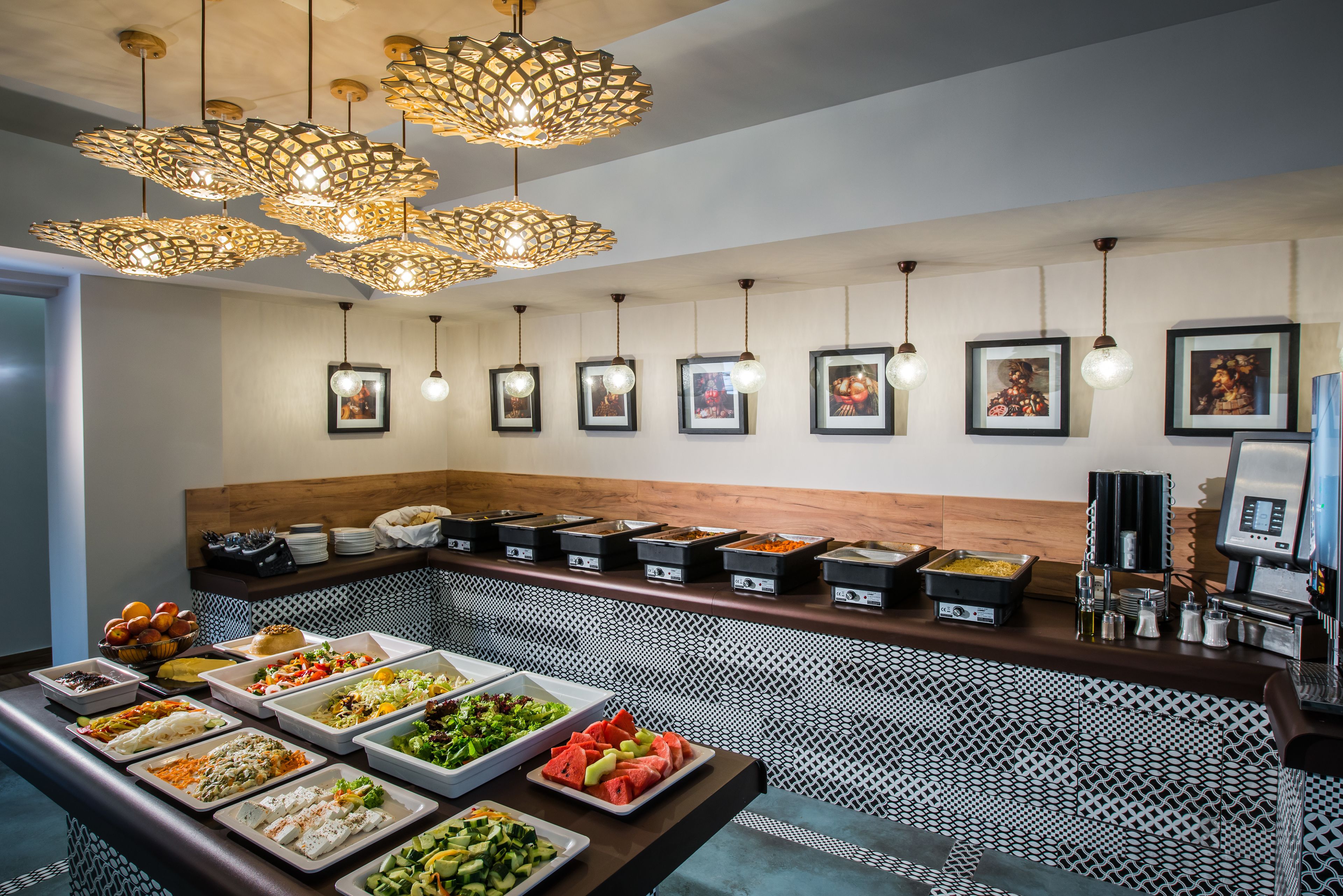 Een buffetgedeelte met diverse etenswaren, een koffiecorner en decoratieve verlichting.