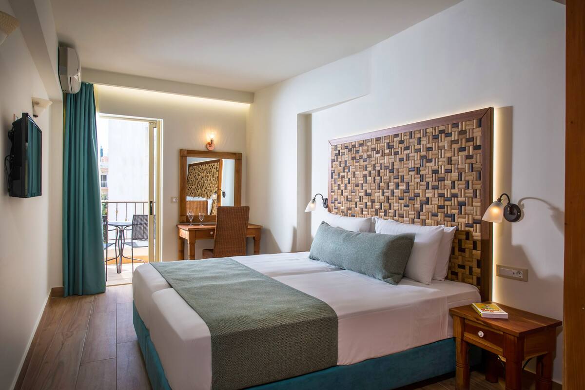 Habitació d'hotel amb un llit gran, un escriptori i una cadira.