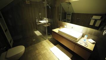 A modern bathroom with a glass-enclosed shower, a large sink, and a mirror above it.