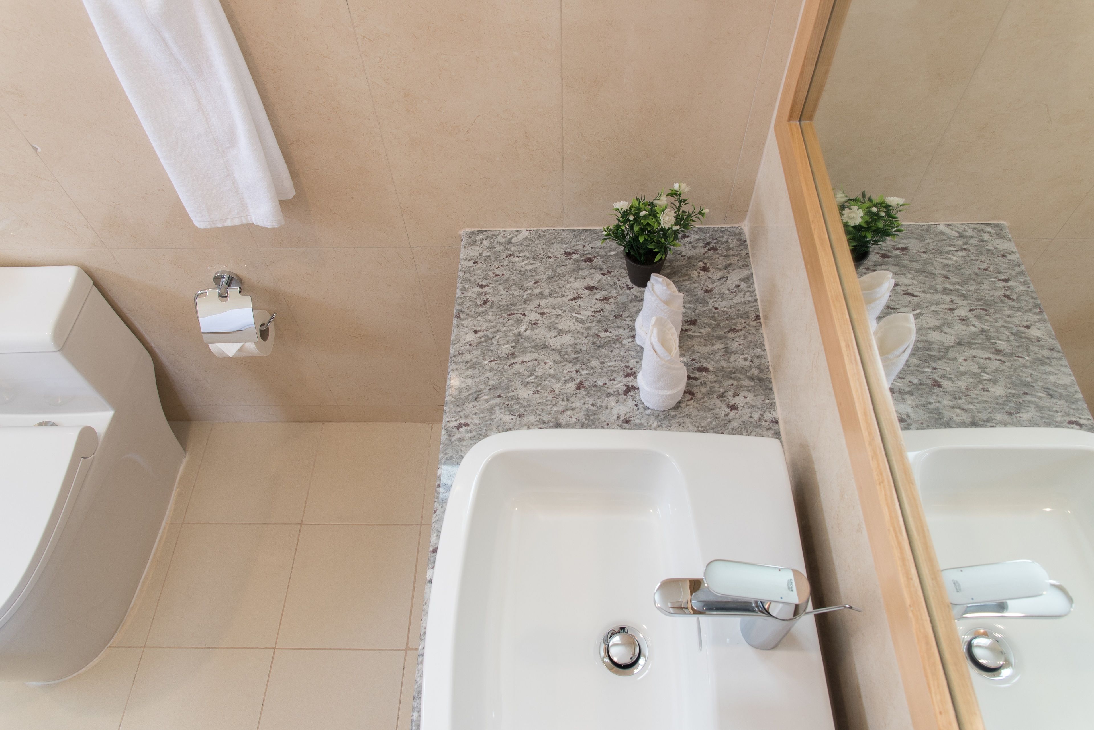 Un baño con dos lavamanos, un inodoro y un perchero para toallas.