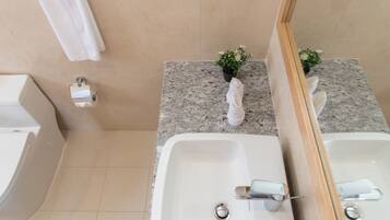 Un baño con dos lavamanos, un inodoro y un perchero para toallas.