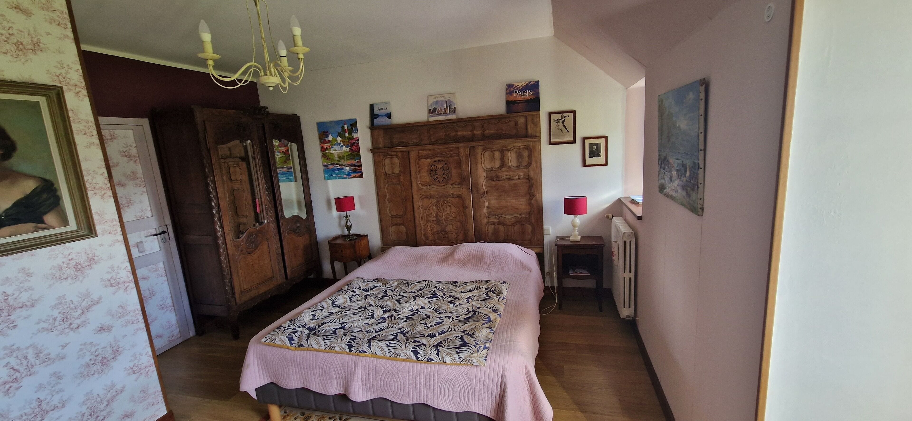 Une chambre à coucher avec un lit, une armoire en bois et un radiateur.