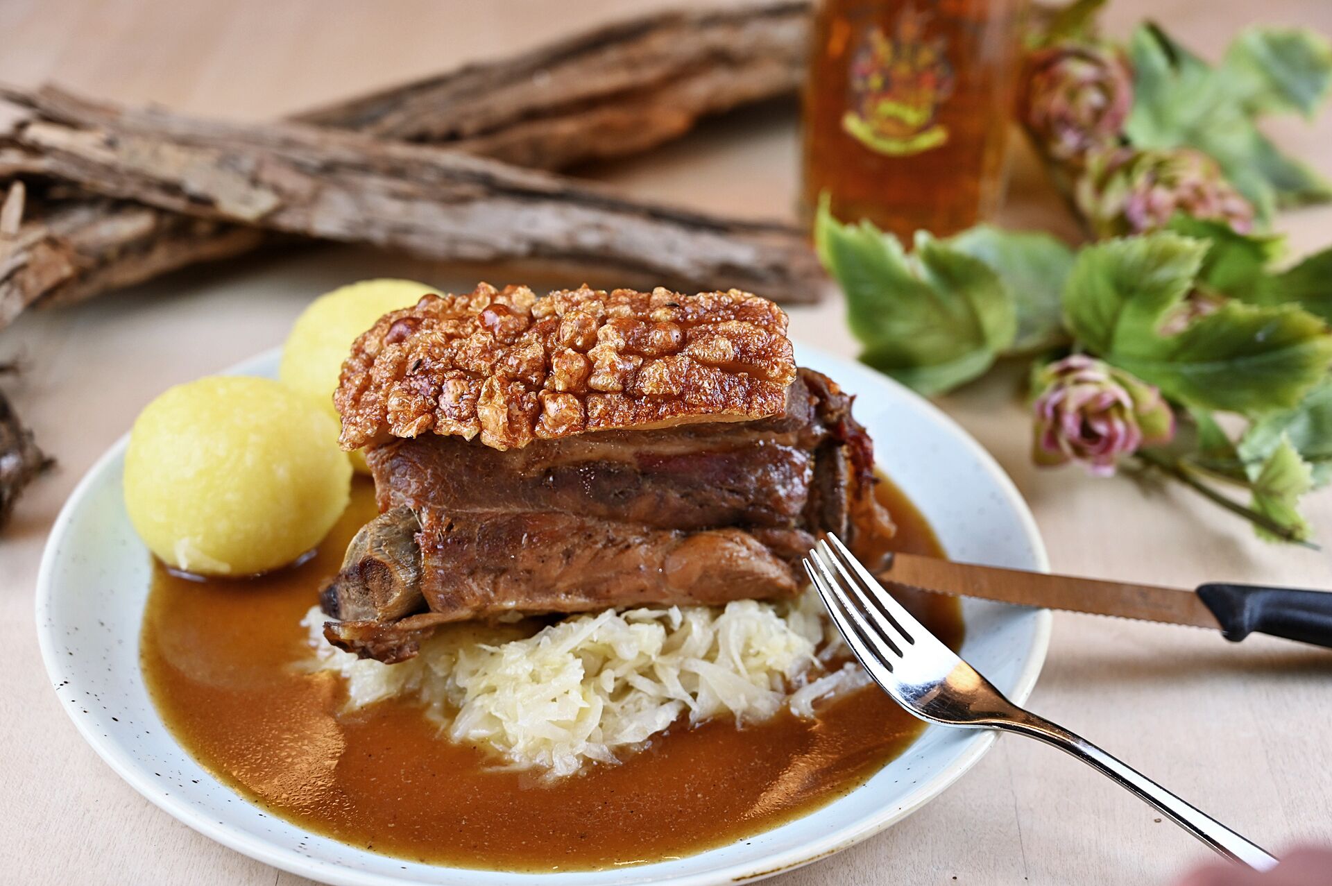 Une assiette contenant un plat de porc rôti, de la choucroute et une sauce.