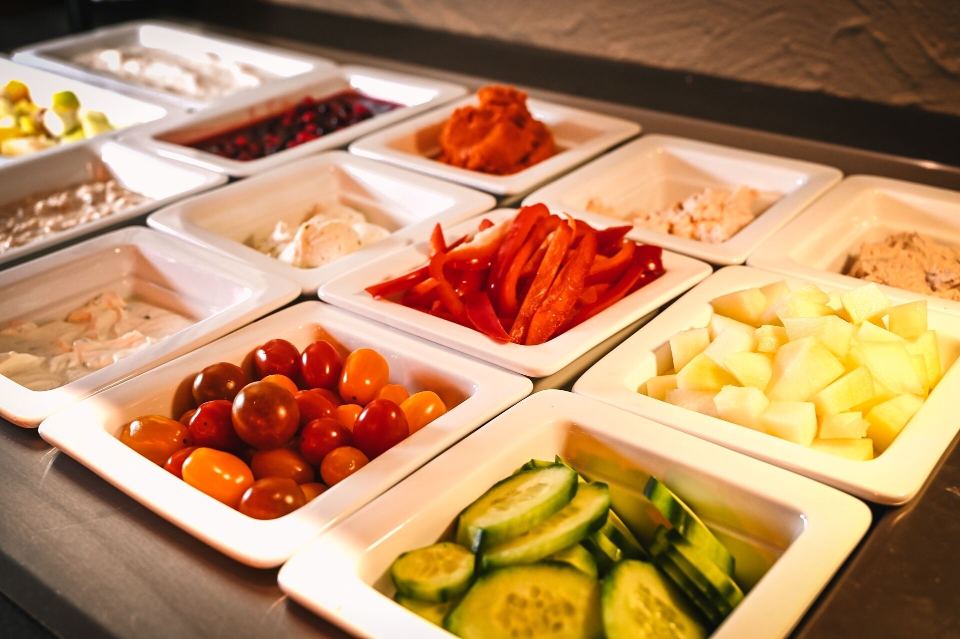 A buffet with various food items including fruits, vegetables, and dips.
