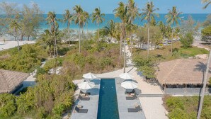 An aerial view of a resort with a swimming pool, lounge chairs, and umbrellas. - Tamu Koh Rong (Koh Rong)