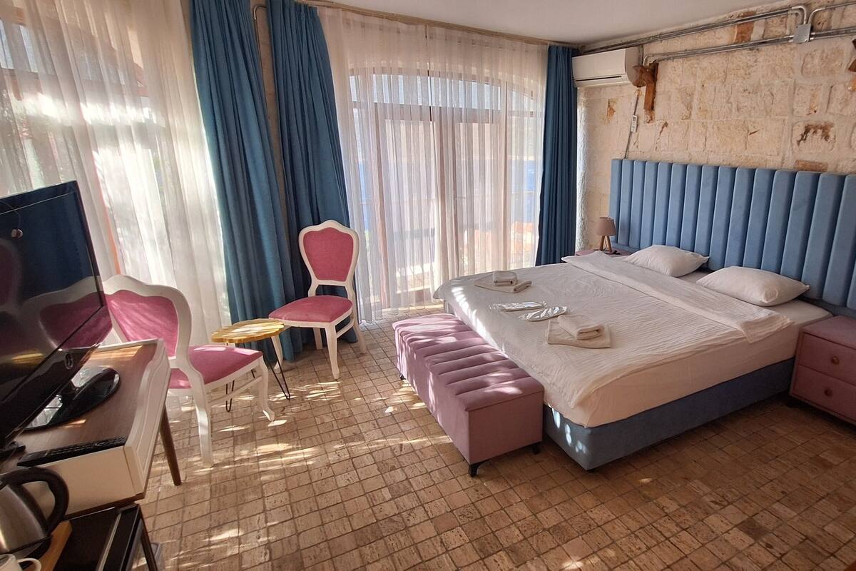 Een hotelkamer met een bed, een bureau, een stoel en een televisie.