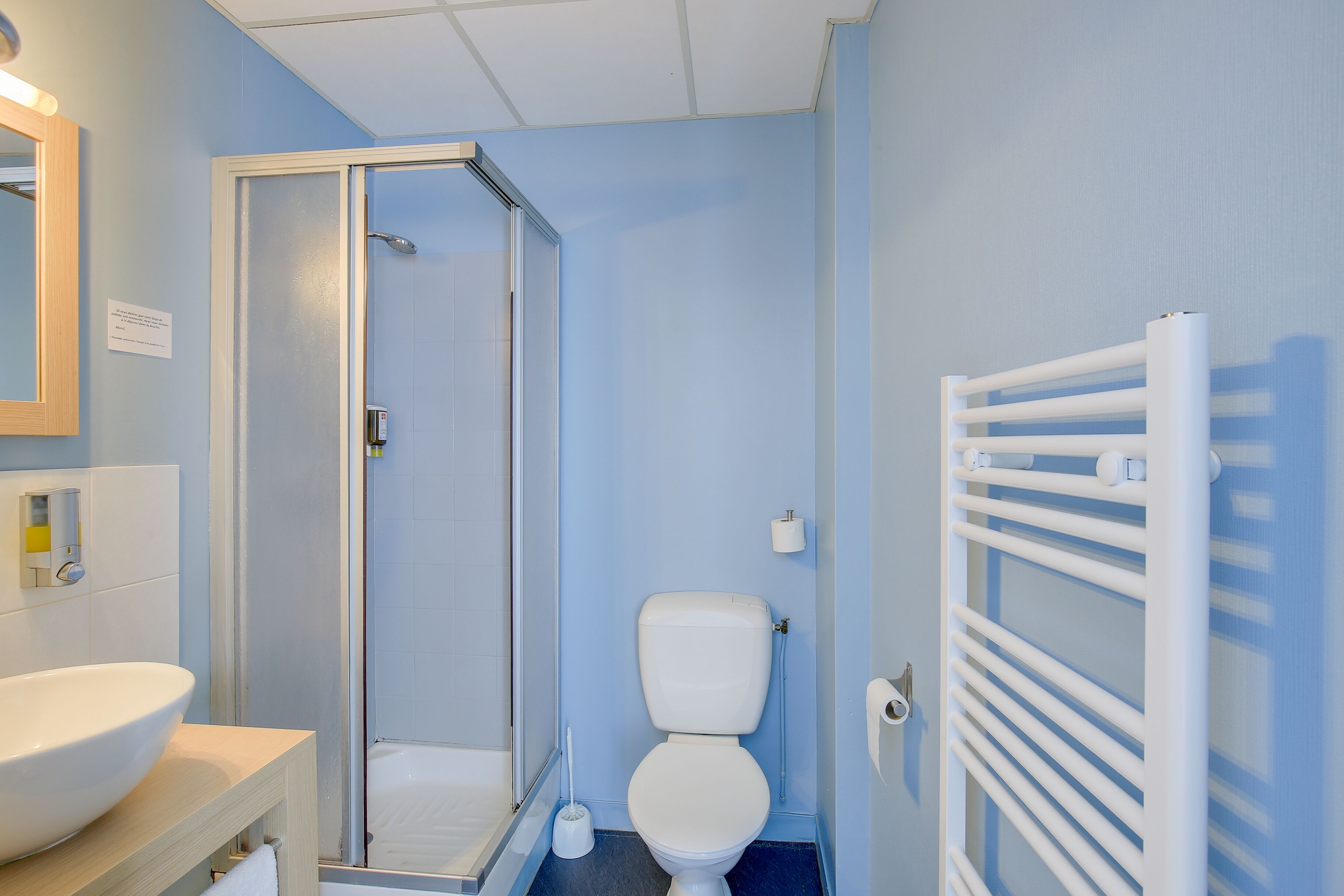 Baño con ducha, inodoro, lavabo y toallero.