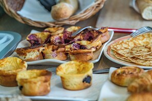 A variety of baked goods including muffins and pancakes on a table.