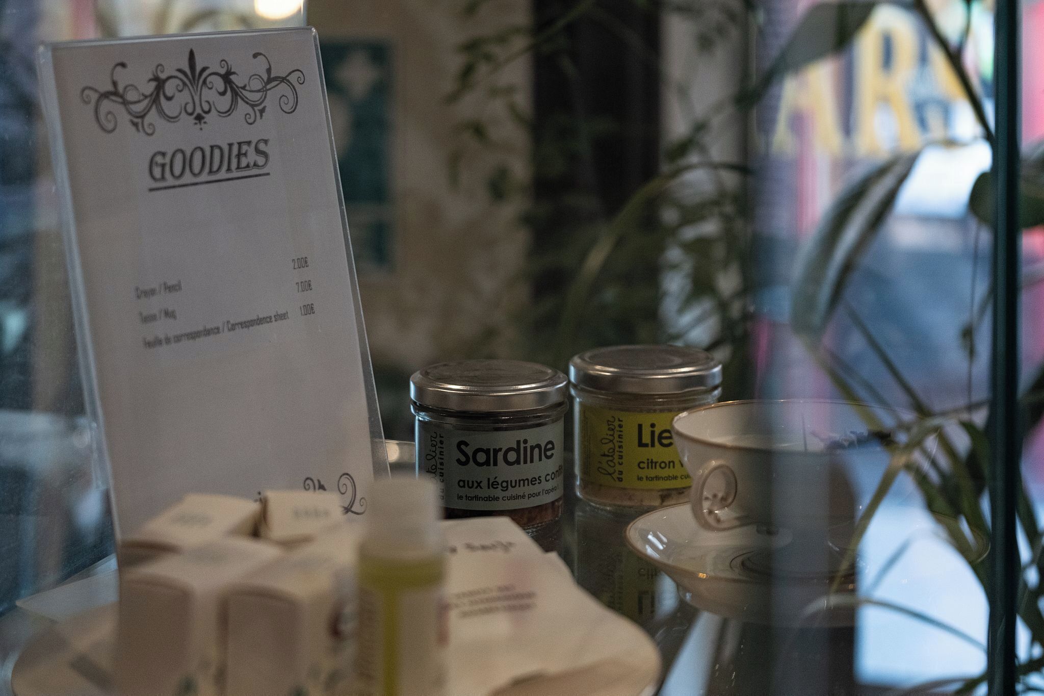 Un panel de menú con el título 'GOODIES' y productos como Sardina y Lie.
