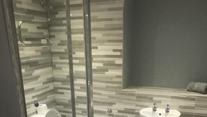 A modern bathroom with a glass shower enclosure, a toilet, and a sink. - Brownlows Inn (Liverpool)