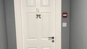 A white door with a silver handle and a bow decoration. - Brownlows Inn (Liverpool)