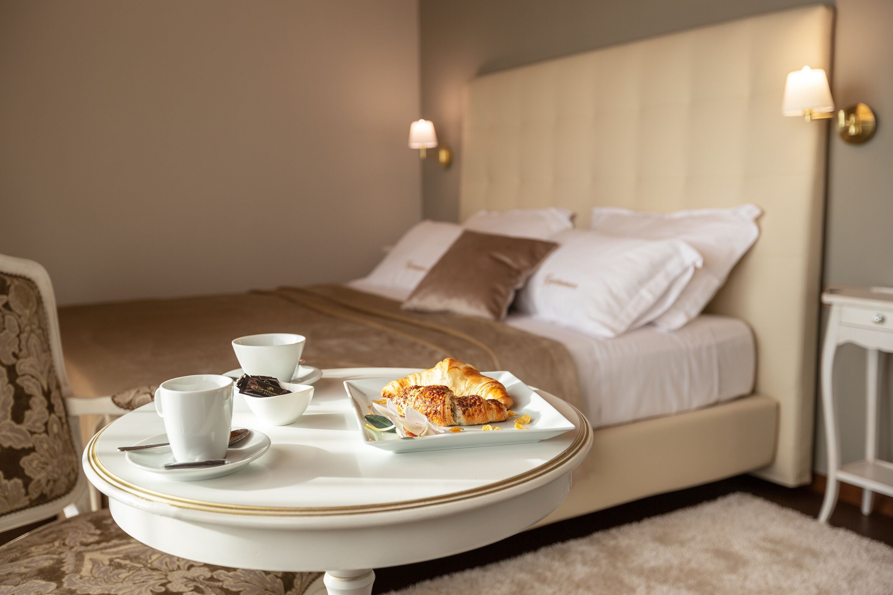 A neatly made bed with pillows and a bedside table with a lamp.