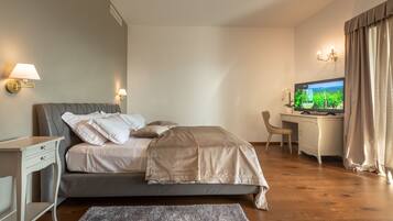 Un dormitorio moderno con cama, mesitas de noche, escritorio y televisor.