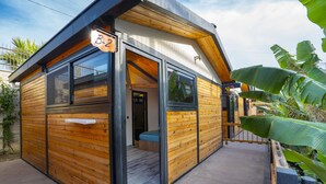Una cabaña moderna de madera con ventanas amplias, un balcón y un letrero que indica la habitación B-2.