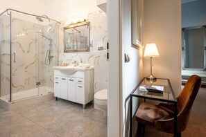 A modern bathroom with a glass-enclosed shower, a white sink, and a vanity with cabinets. - Holiday Suites Cracow (Kraków)