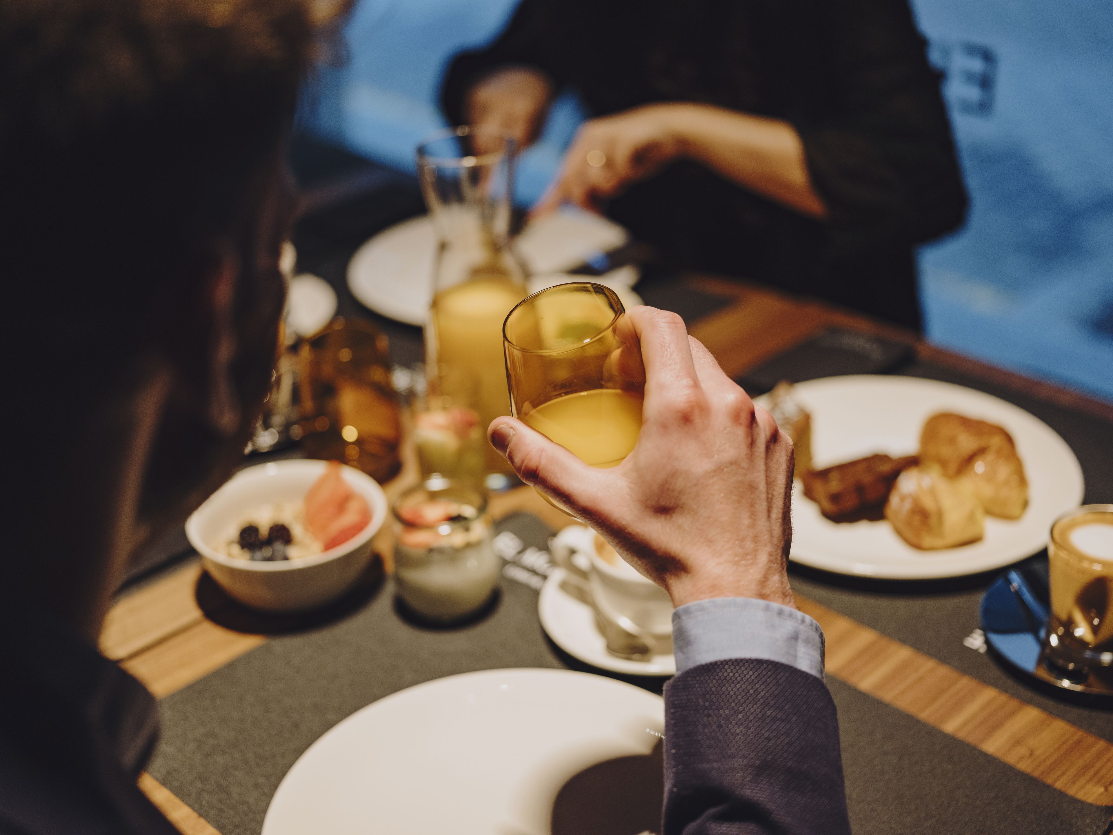 Una mesa de comedor con platos, vasos y una taza.