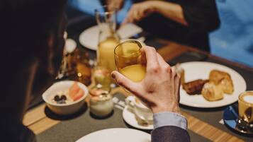 Una mesa de comedor con platos, vasos y una taza.
