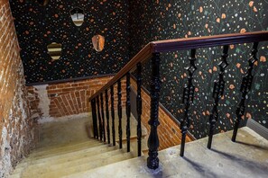 Staircase features a floral-patterned wall and a handrail with black balusters.
