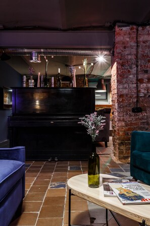 Relax in this inviting living area with a piano, round table, and comfortable seating.