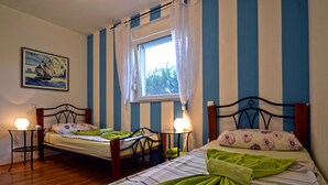 A bedroom with two beds, a window with curtains, a painting on the wall, and bedside lamps. - Villa Margherita (Kanfanar)