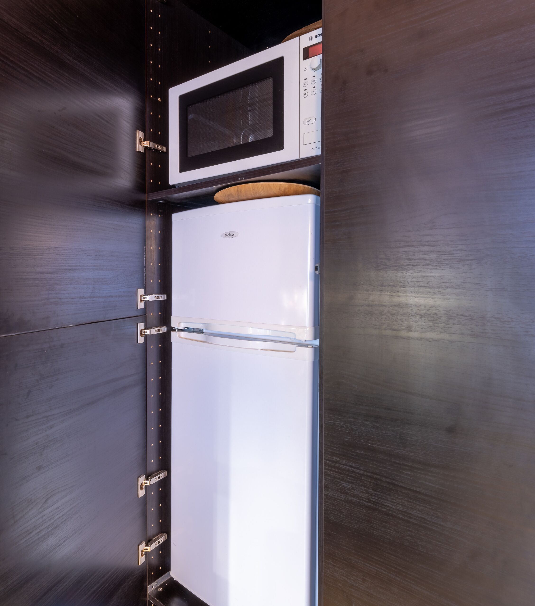 A compact kitchen with a microwave and a refrigerator.