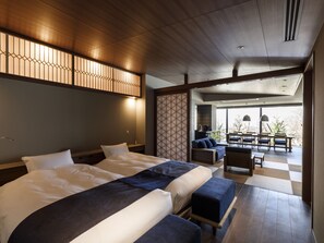 Une chambre d’hôtel avec un grand lit, un coin salon avec vue et un balcon.
