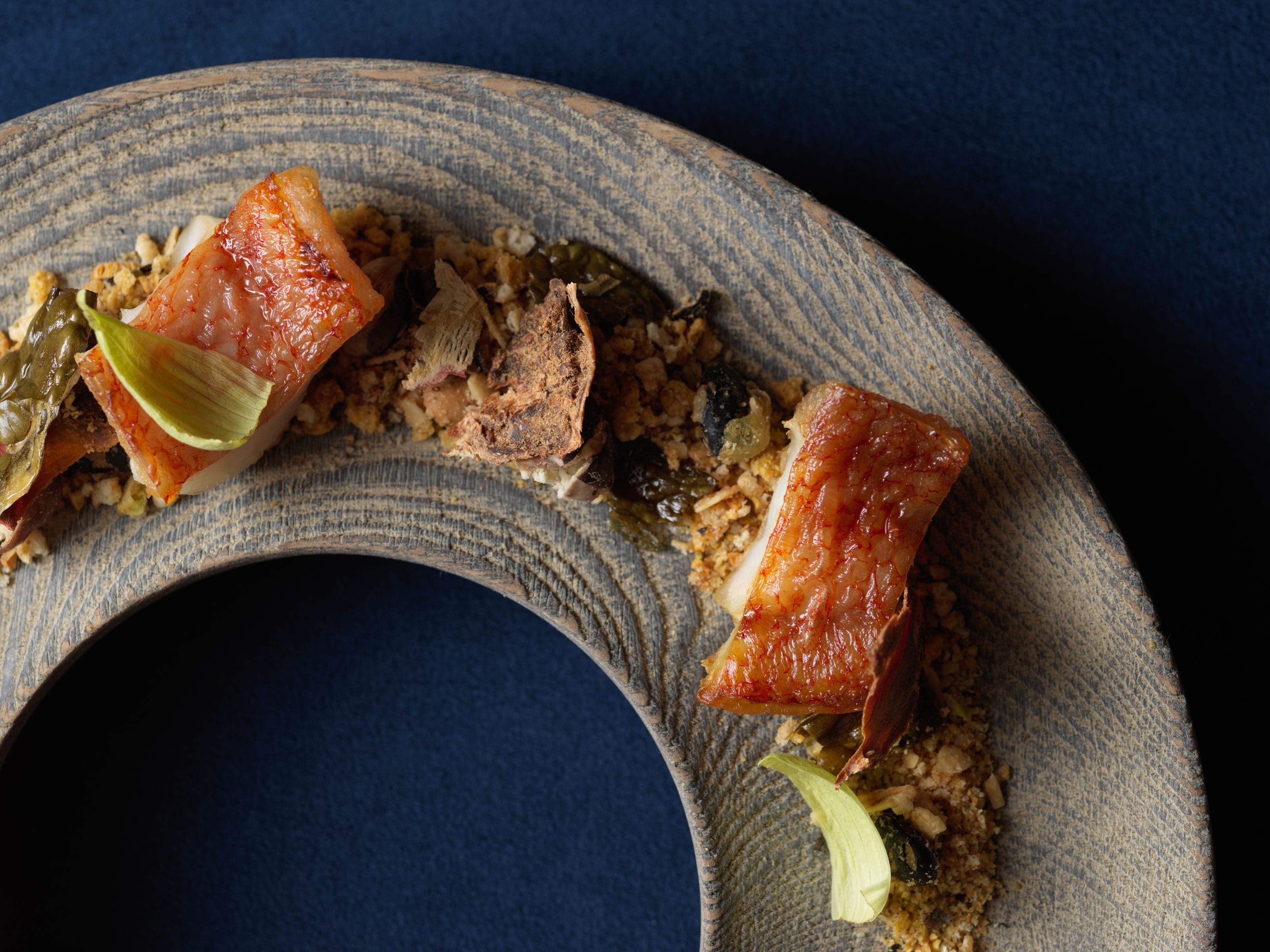 A plate with food, including pieces of meat and vegetables.