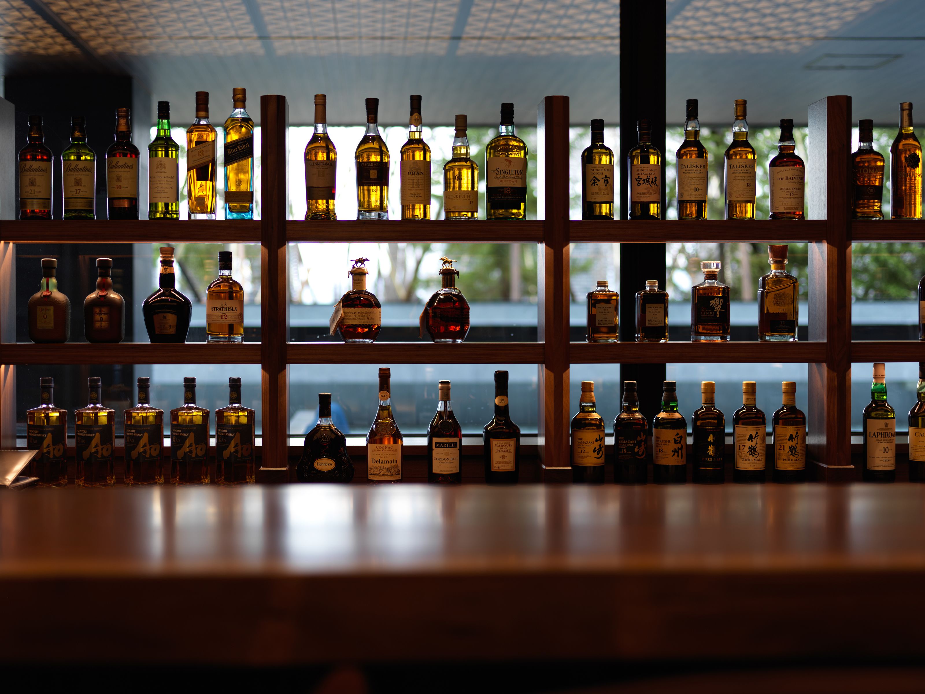 A bar with multiple shelves of liquor bottles.