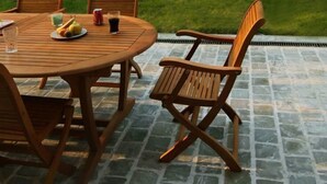 A round wooden table with four chairs, a plate of fruit, and a glass of water. - Les Tourelles de Thun (Meulan-en-Yvelines)