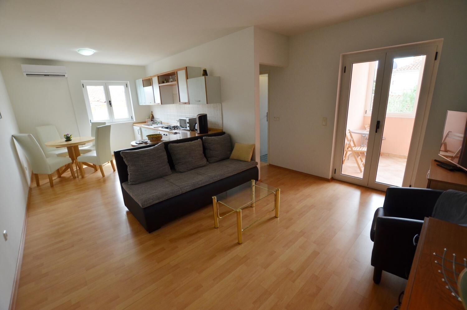 A modern living room with a sofa, coffee table, and dining area.