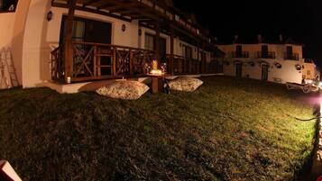 A traditional chalet-style building with a wooden balcony and a lit table in the foreground.