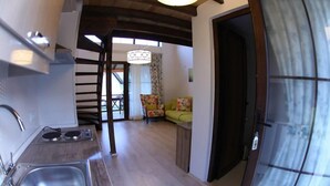 A kitchen with a sink and stove, a staircase leading to a dining area, and a door to another room. - Karaburun Mimoza Apart Hotel (Karaburun)