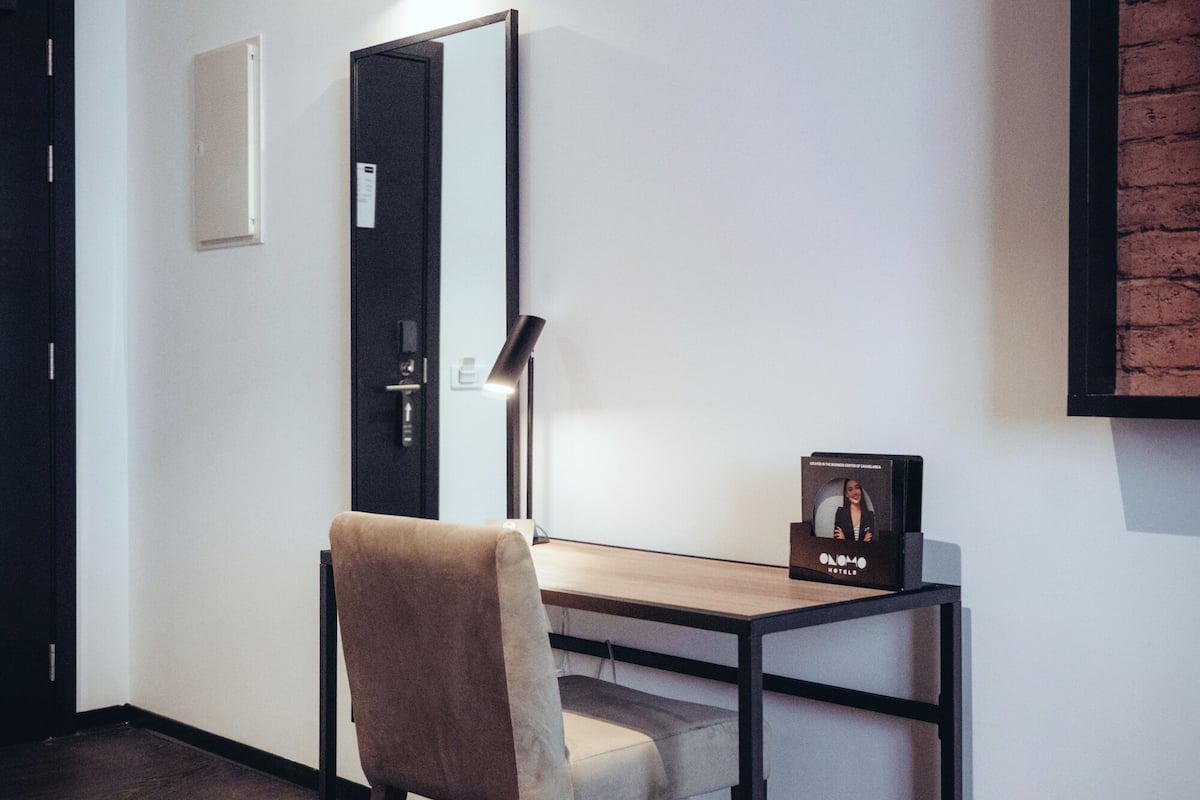 Ein moderner Arbeitsraum mit Schreibtisch, Stuhl und einem gerahmten Bild an der Wand.