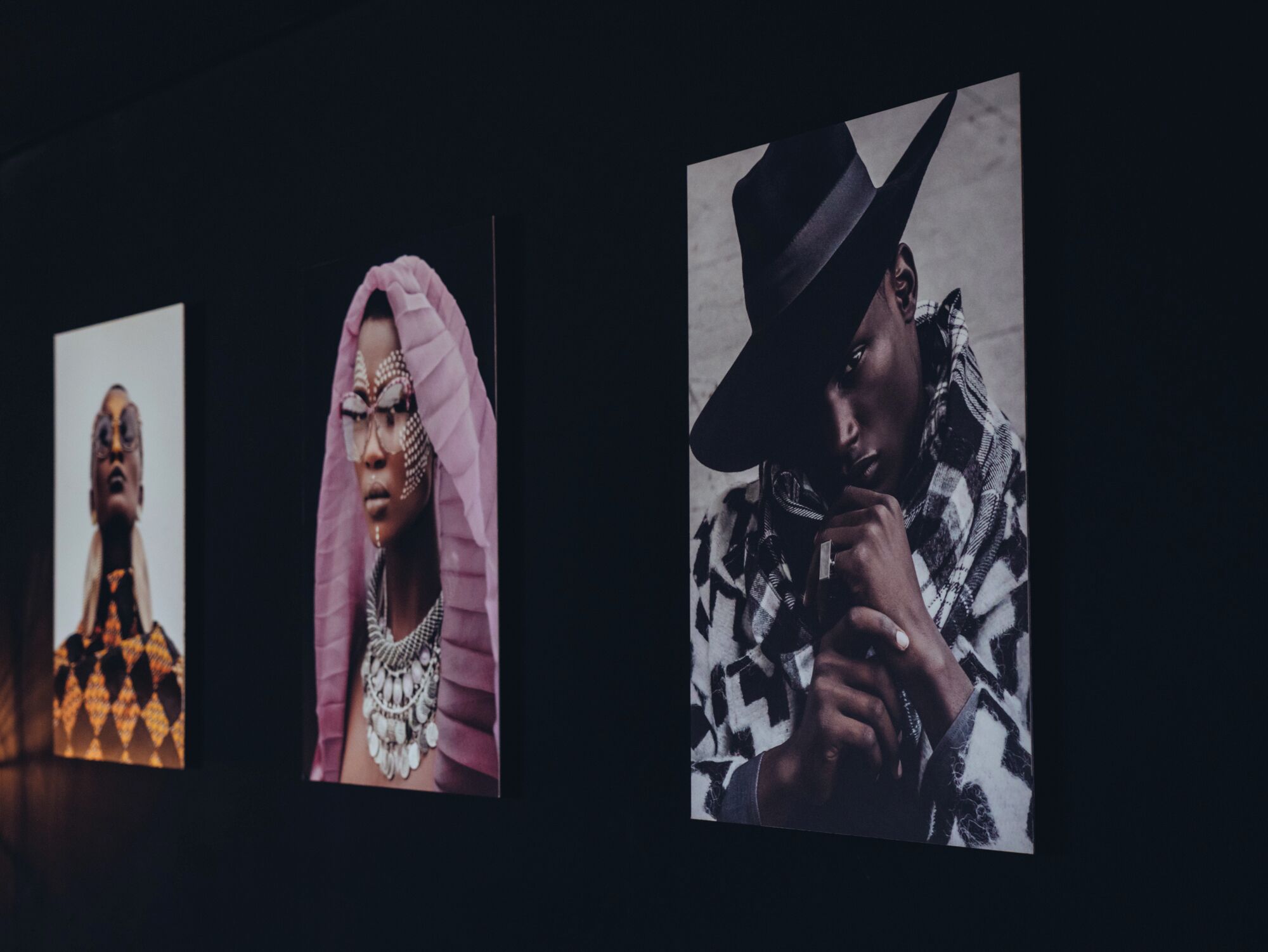 Trois photographies encadrées accrochées au mur.