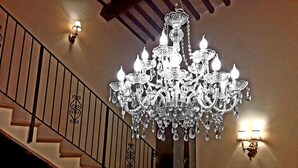 A grand staircase with a crystal chandelier and wall sconces. - Suite Assisi (Assisi)
