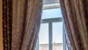 A room with a window and a view of a building outside. - Suite Assisi (Assisi)