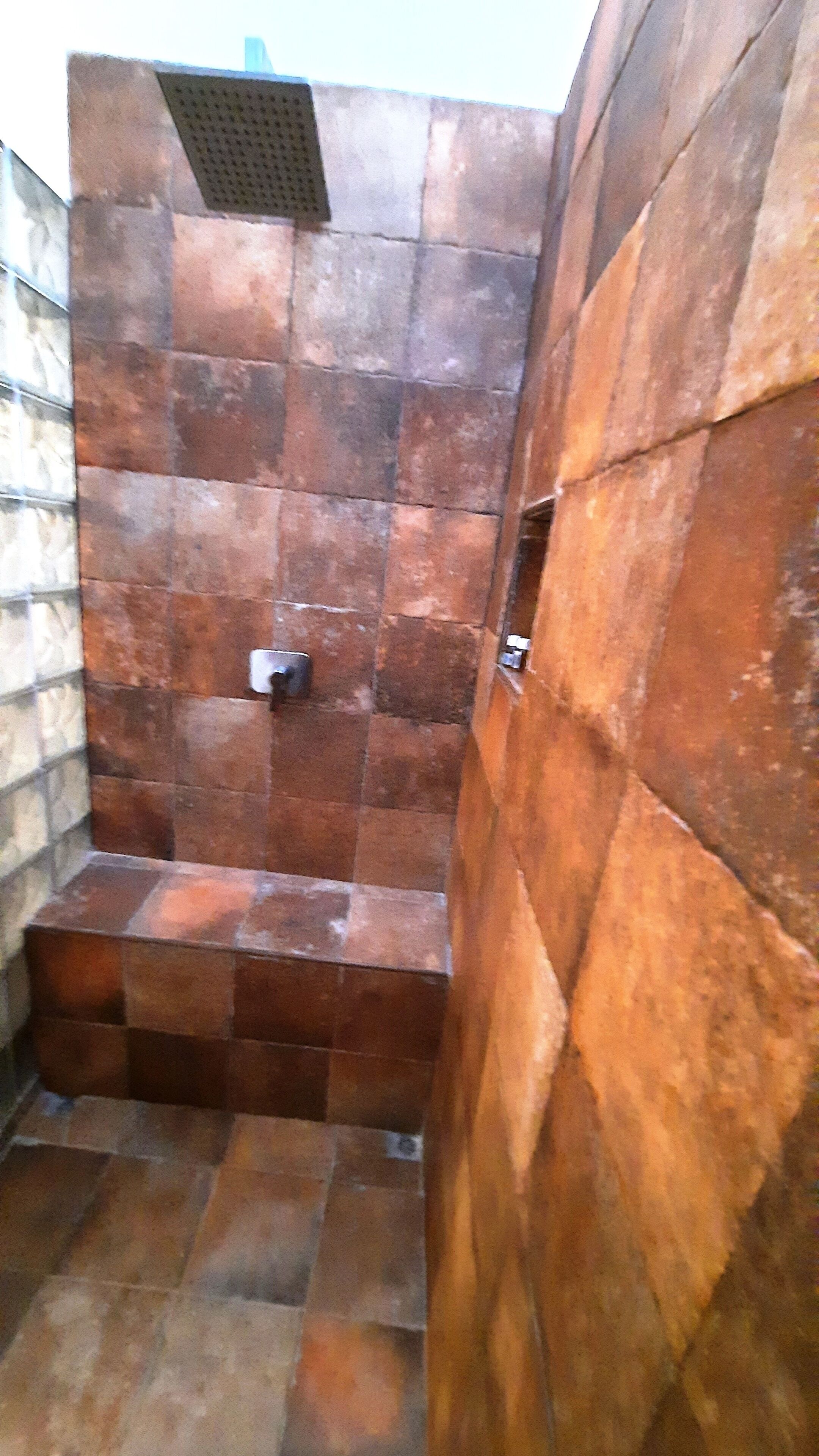A shower area with tiled walls and a metal showerhead.
