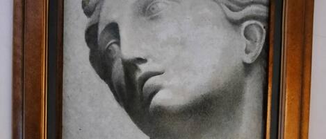Una escultura enmarcada de la cabeza de una mujer con trenzas.