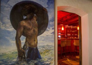 A painting of a man with a large hat, a bar area with shelves of bottles, and a tiled floor.