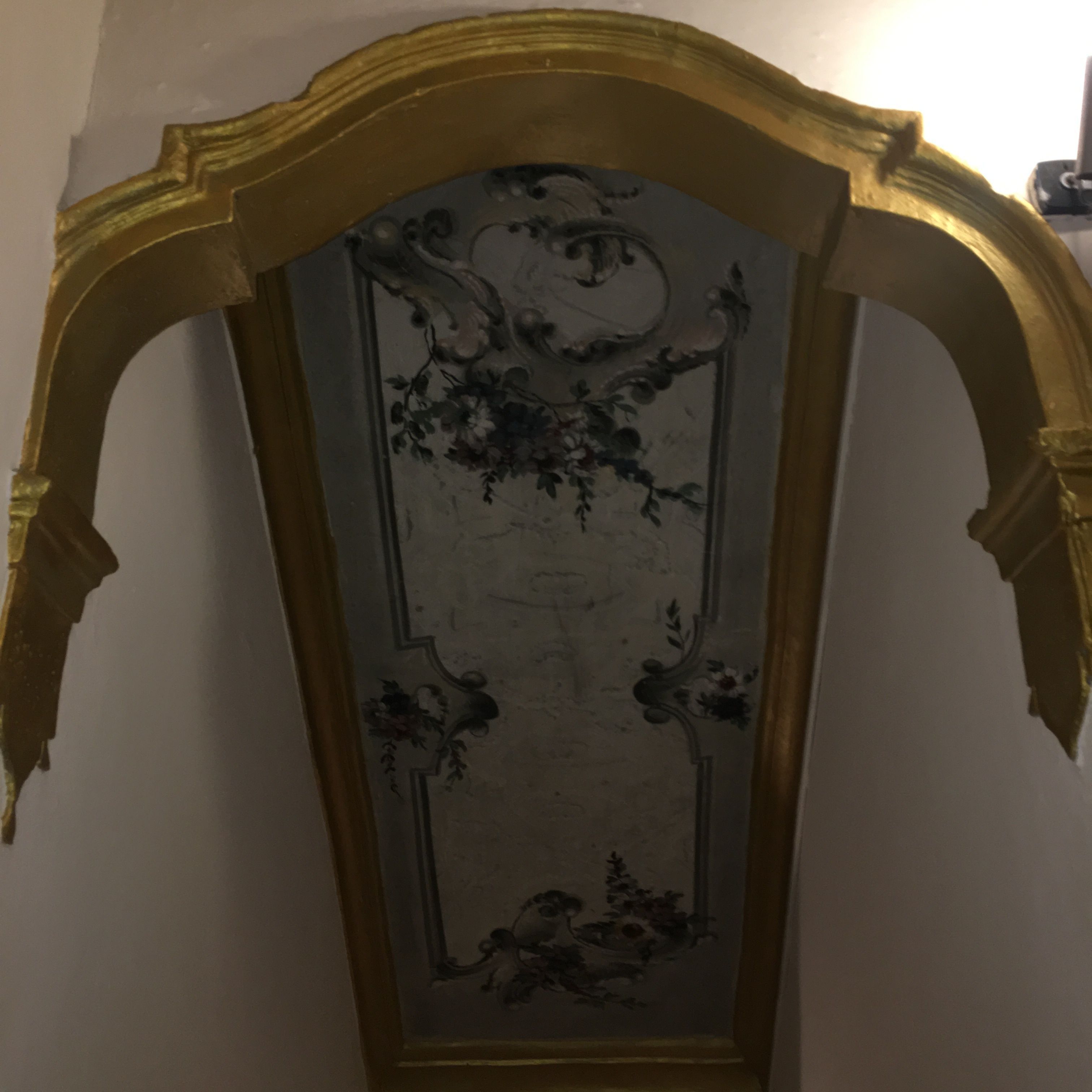 A wall with a decorative panel featuring a floral design.