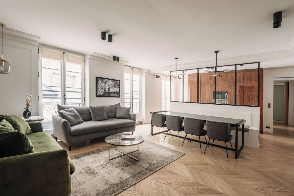 A modern living room with a sofa, coffee table, and dining area.
