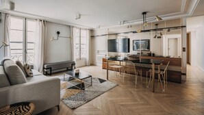 A modern kitchen with a dining area, a sofa, and a bench. - HIGHSTAY - Luxury Serviced Apartments - Place Vendôme (Paris)