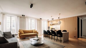 A modern living room with a sofa, coffee table, and dining area. - HIGHSTAY - Luxury Serviced Apartments - Place Vendôme (Paris)