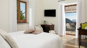 A bedroom with a bed, a desk, a TV, and a balcony with a view. - Villa Amiela (Massa Lubrense)