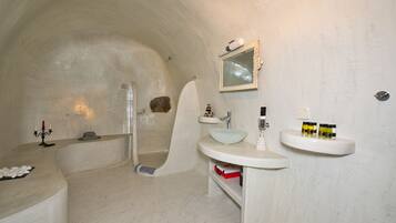 A bathroom with a bathtub, a sink, and a mirror.